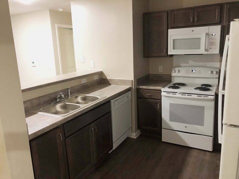 a kitchen with white appliances and brown cabinets